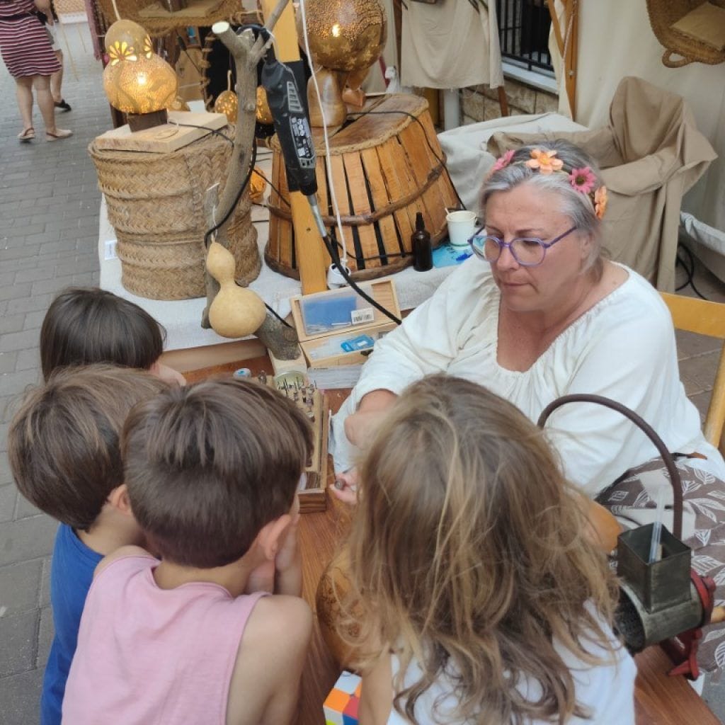 Artesana explicando su trabajo a ñiños